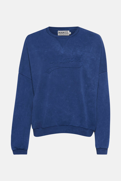 Gilet bleu de Le Fabuleux Marcel de Bruxelles, avec logo brodé sur la poitrine.