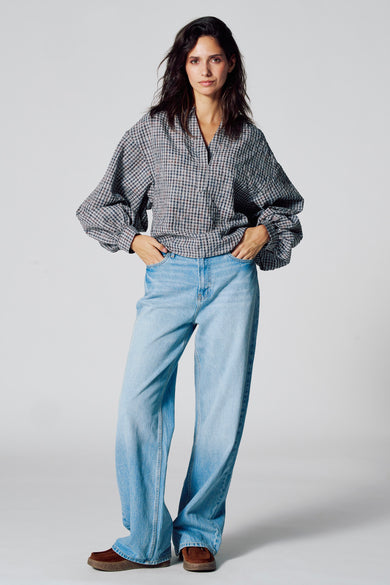 Blouse multicolore à longues manches de Le Fabuleux Marcel de Bruxelles, avec un motif rayé, associée à des jeans bleus et des chaussures marrons.