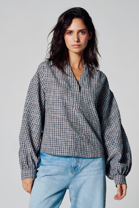 Blouse multicolore à longues manches de Le Fabuleux Marcel de Bruxelles, avec un motif à carreaux, associée à un jean.