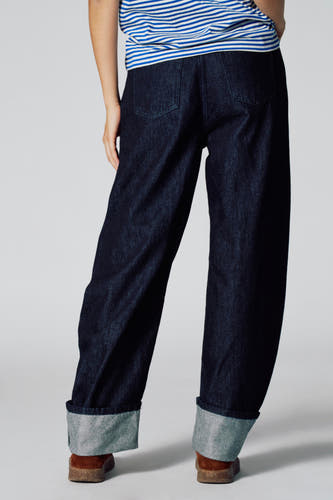 Jean denim bleu marine LE JEAN BALLOON de Le Fabuleux Marcel de Bruxelles, avec des poches rabattues et un haut rayé.