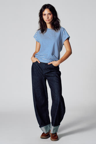 T-shirt rayé bleu de manches courtes de Le Fabuleux Marcel de Bruxelles, associé à des jeans larges et des chaussures marrons.