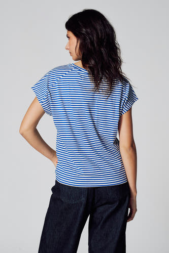 T-shirt bleu rayé à manches courtes de Le Fabuleux Marcel de Bruxelles, porté avec un pantalon foncé, vu de derrière.