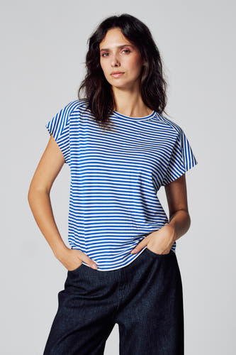 T-shirt rayé bleu avec manches courtes de Le Fabuleux Marcel de Bruxelles, porté avec un pantalon foncé.