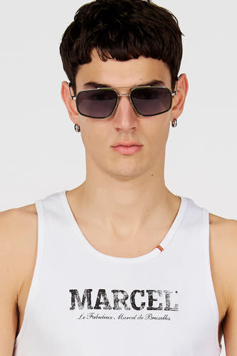 Lunettes de soleil vertes de Le Fabuleux Marcel de Bruxelles, avec une monture en métal et des verres foncés, portées par une personne avec une chemise blanche.