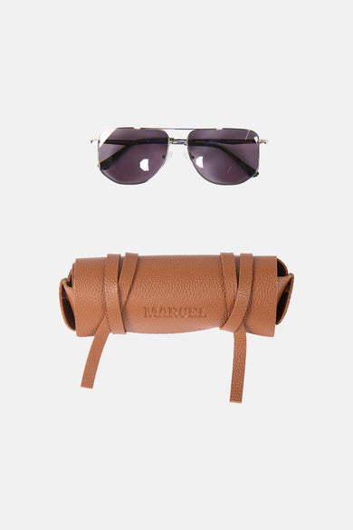 Lunettes de soleil bleues de Le Fabuleux Marcel de Bruxelles, avec un étui en cuir marron portant le nom de la marque.
