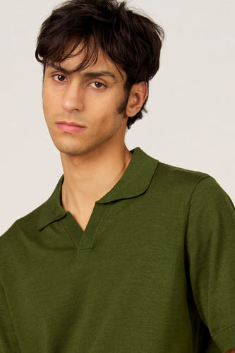 Groene polo van Le Fabuleux Marcel de Bruxelles, met korte mouwen en een open kraag.