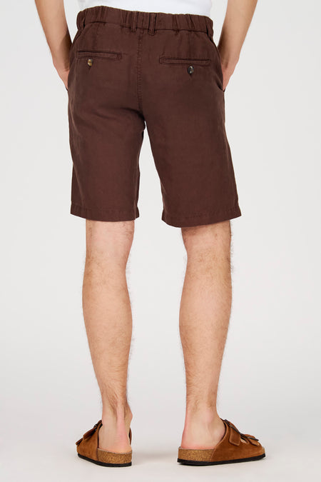 Bruine bermuda van Le Fabuleux Marcel de Bruxelles, achterkant met zakken en knoopjes, gedragen met suède sandalen.