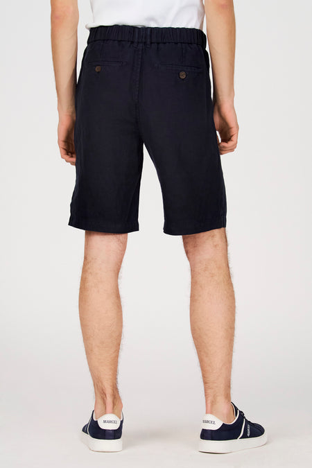 Blauwe bermuda van Le Fabuleux Marcel de Bruxelles, gezien van achteren, met elastische tailleband en knoopdetails op de achterzakken.