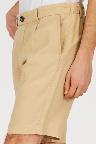 Beige bermuda van Le Fabuleux Marcel de Bruxelles, met plooien en steekzak, in een cropped weergave.