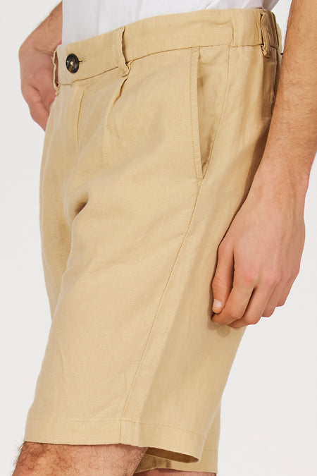 Beige bermuda van Le Fabuleux Marcel de Bruxelles, met plooien en steekzak, in een cropped weergave.