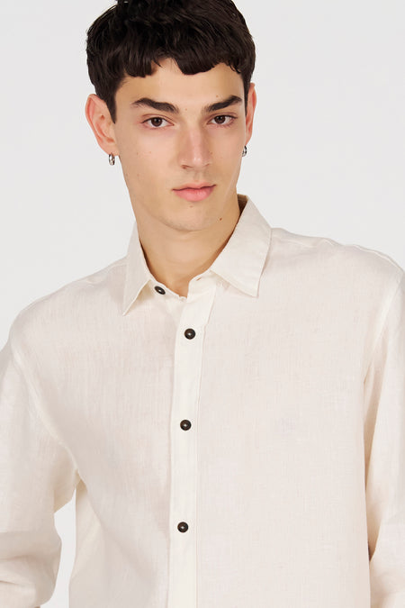 Chemise blanche en lin à manches longues de Le Fabuleux Marcel de Bruxelles, avec boutons foncés.