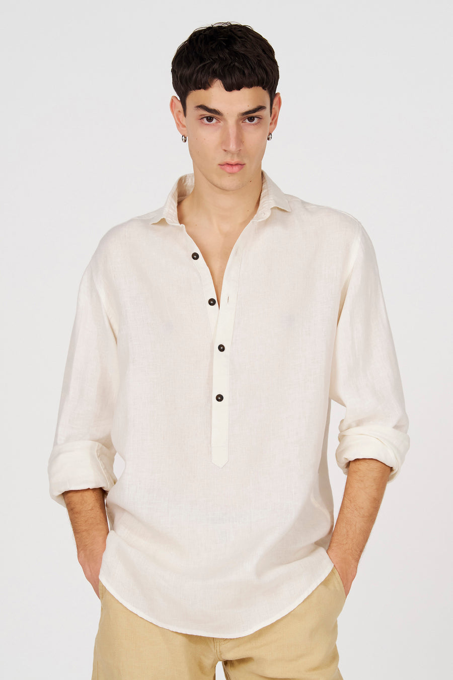Chemise blanche en lin de Le Fabuleux Marcel de Bruxelles avec une demi-patte de boutonnage et des manches retroussées.