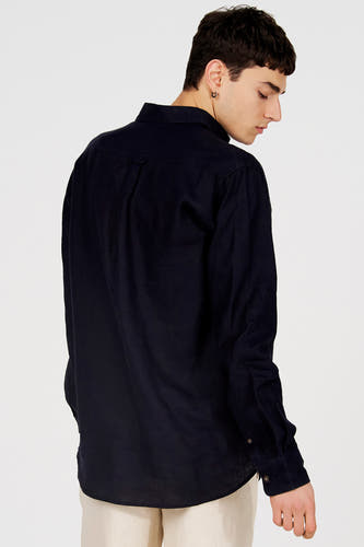 Chemise bleu foncé de Le Fabuleux Marcel de Bruxelles avec tissu texturé, vue de dos sur un mannequin portant un pantalon clair.