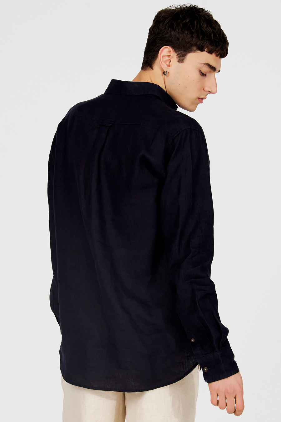 Chemise bleu foncé de Le Fabuleux Marcel de Bruxelles avec tissu texturé, vue de dos sur un mannequin portant un pantalon clair.