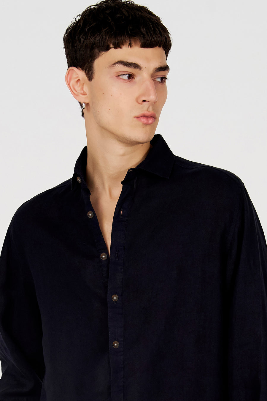 Chemise bleue de Le Fabuleux Marcel de Bruxelles, à manches longues, boutons marron et col ouvert, portée par un mannequin.