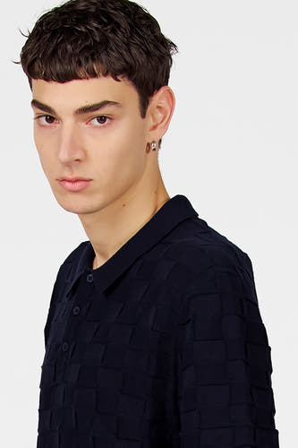 Pull bleu à col en V de Le Fabuleux Marcel de Bruxelles, avec un motif à carreaux tissé et un col polo.