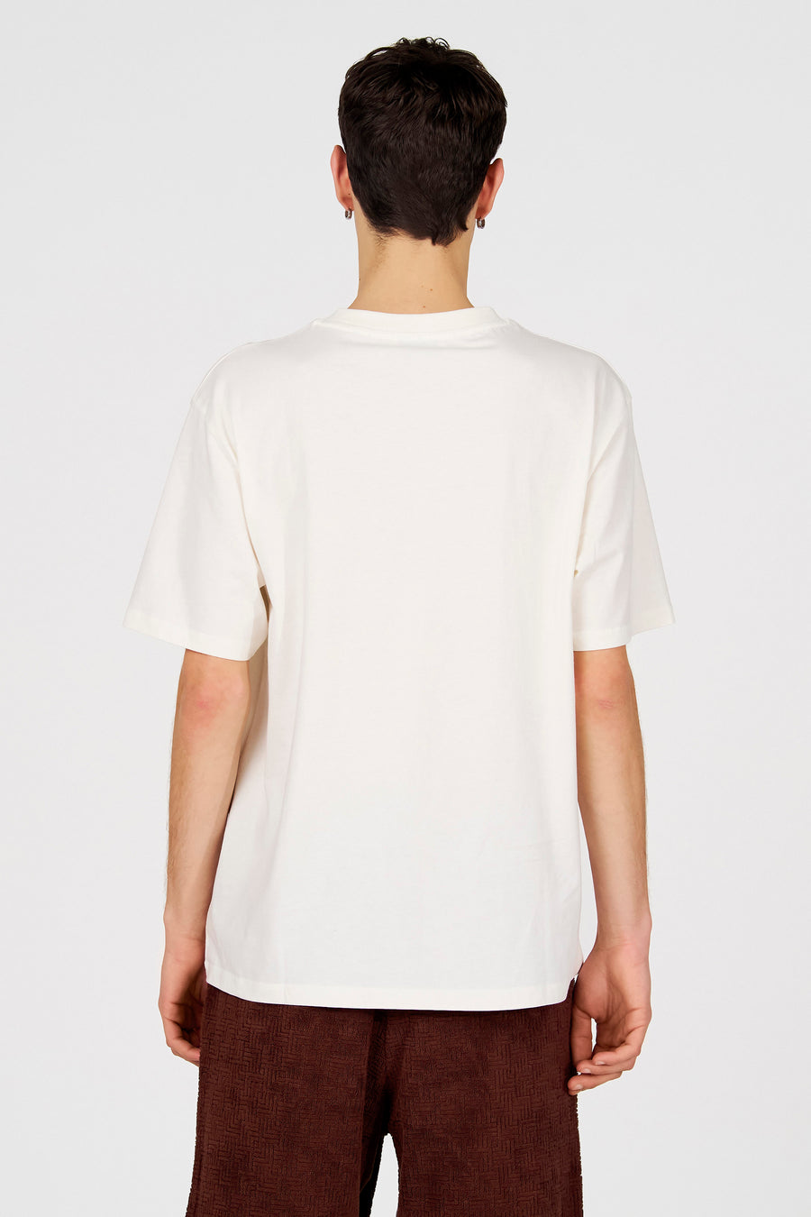 Wit T-shirt met korte mouwen van Le Fabuleux Marcel de Bruxelles, rugzijde, gecombineerd met een bruine broek.