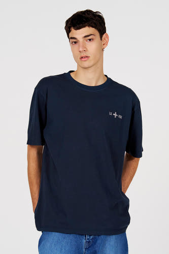 T-shirt bleu à manches courtes de Le Fabuleux Marcel de Bruxelles, vue de dos avec détail de rayure colorée dans le cou et porté avec un jean.
