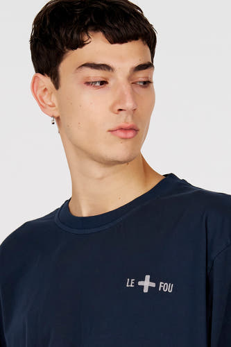 T-shirt bleu à manches courtes de Le Fabuleux Marcel de Bruxelles, avec inscription 'Le Fou' et écusson croix.