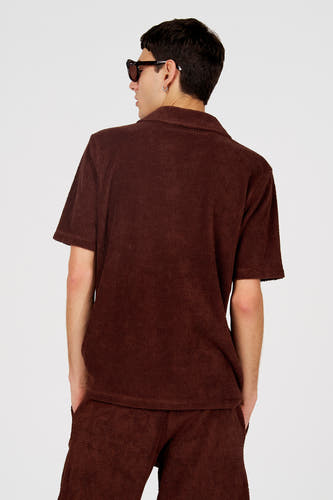 Polo marron de Le Fabuleux Marcel de Bruxelles, avec un motif texturé unique, vue de dos.