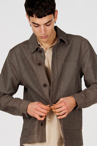 Veste courte marron de Le Fabuleux Marcel de Bruxelles, avec fermeture à boutons et chemise beige en dessous.