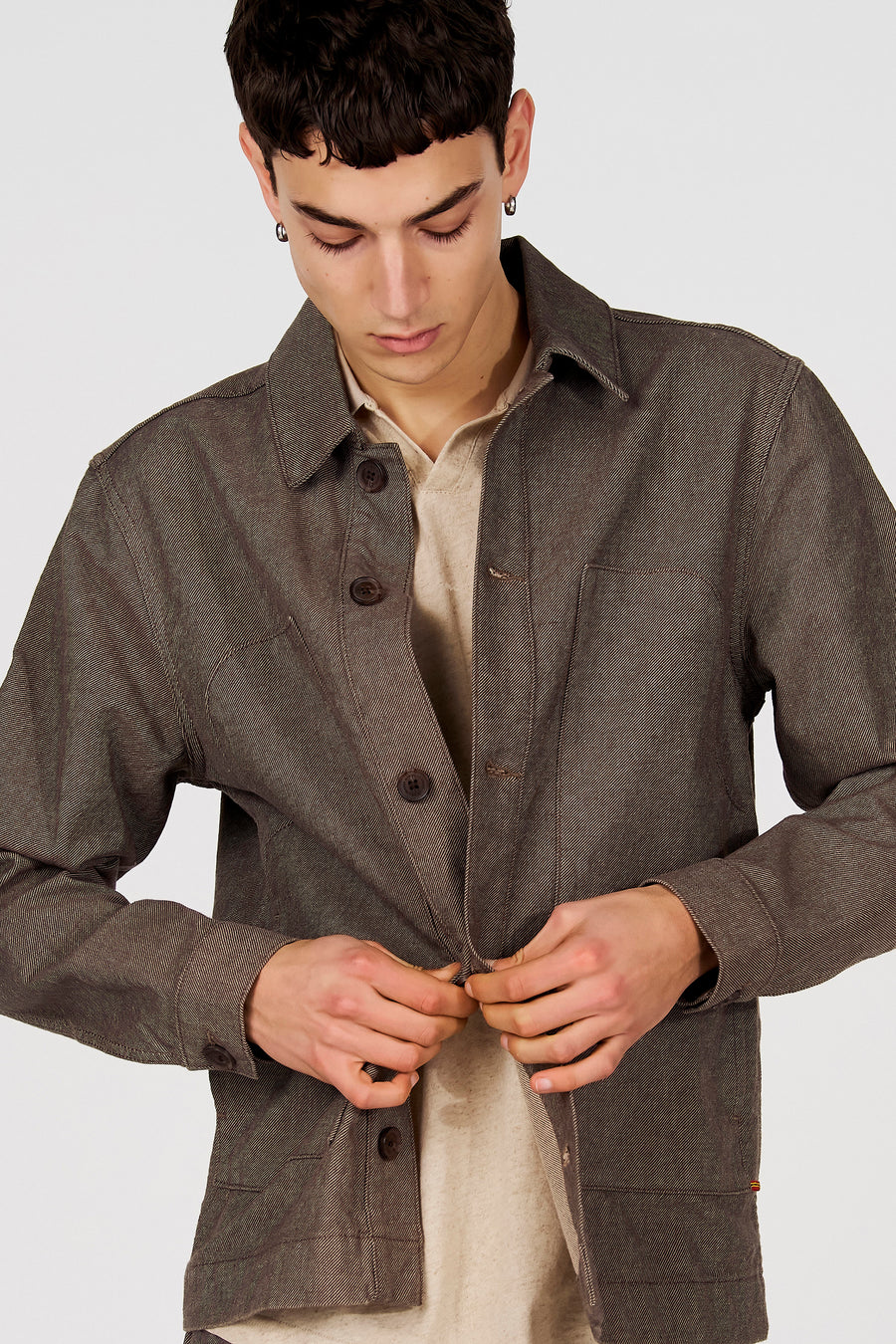 Veste courte marron de Le Fabuleux Marcel de Bruxelles, avec fermeture à boutons et chemise beige en dessous.