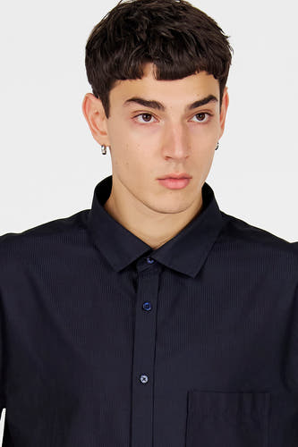 Chemise bleue à manches longues de Le Fabuleux Marcel de Bruxelles, avec un motif à fines rayures verticales et une poche poitrine.