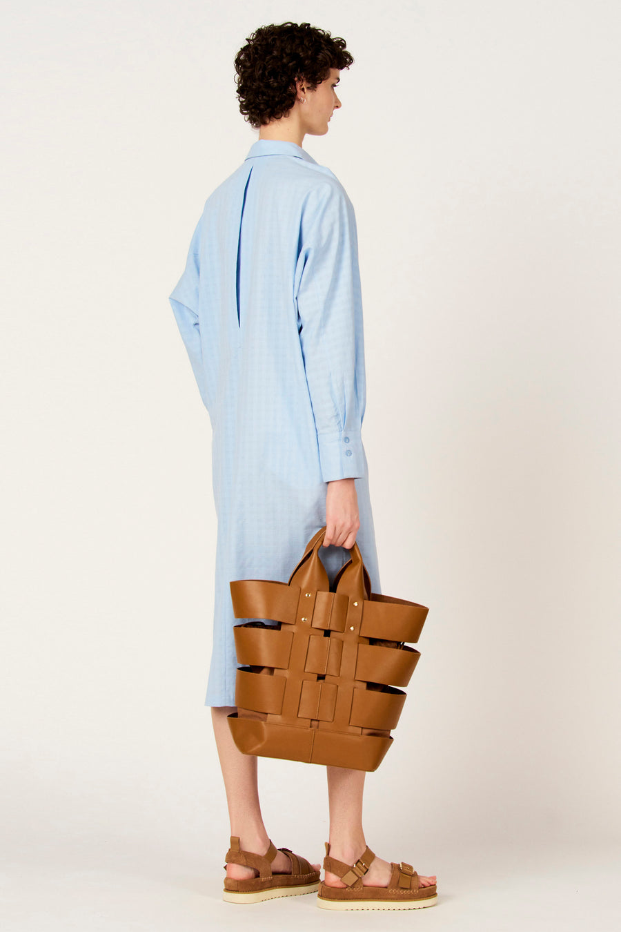 Sac à main marron de Le Fabuleux Marcel de Bruxelles, avec un design tissé et des sandales marron.