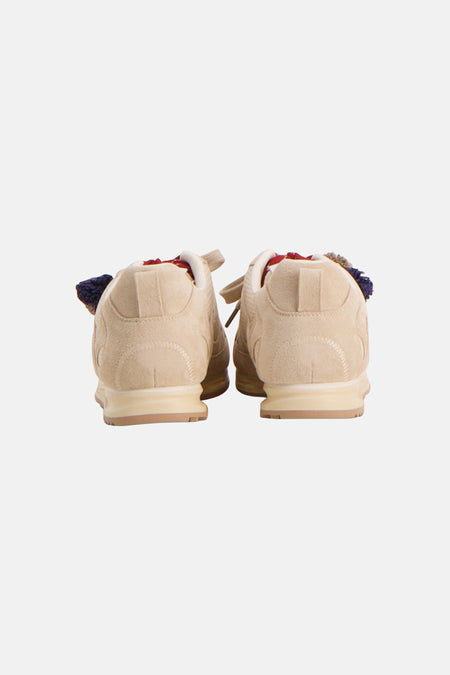 Beige sneakers van Le Fabuleux Marcel de Bruxelles, met suède textuur en decoratieve details aan de achterkant.
