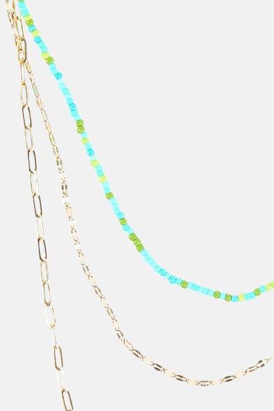Collier court multicolore de Le Fabuleux Marcel de Bruxelles, avec chaînes dorées et perles bleues et vertes.