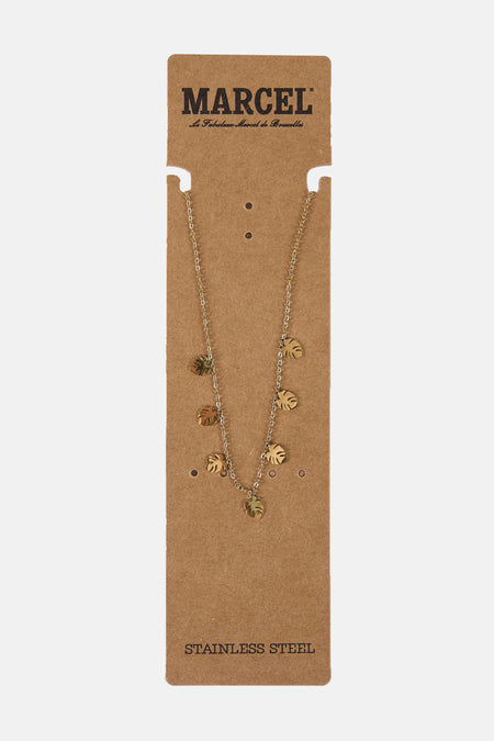 Gouden ketting met bladeren op kartonnen verpakking.