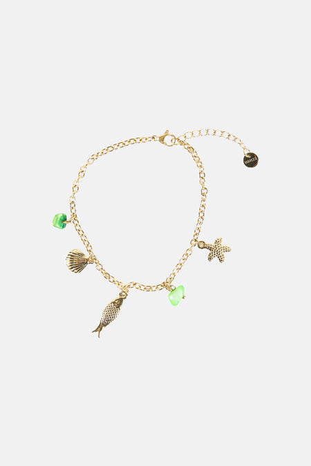 Bracelet multicolore de Le Fabuleux Marcel de Bruxelles avec chaîne dorée et breloques à accents verts, comme une coquille et un poisson.