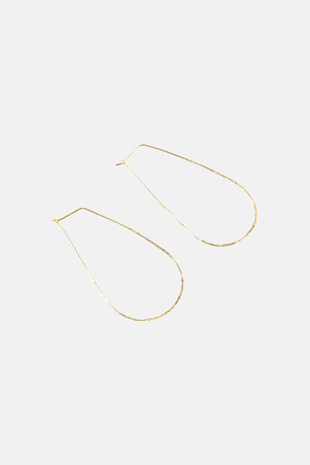 Boucles d'oreilles dorées de Le Fabuleux Marcel de Bruxelles avec un design minimaliste en forme de goutte.