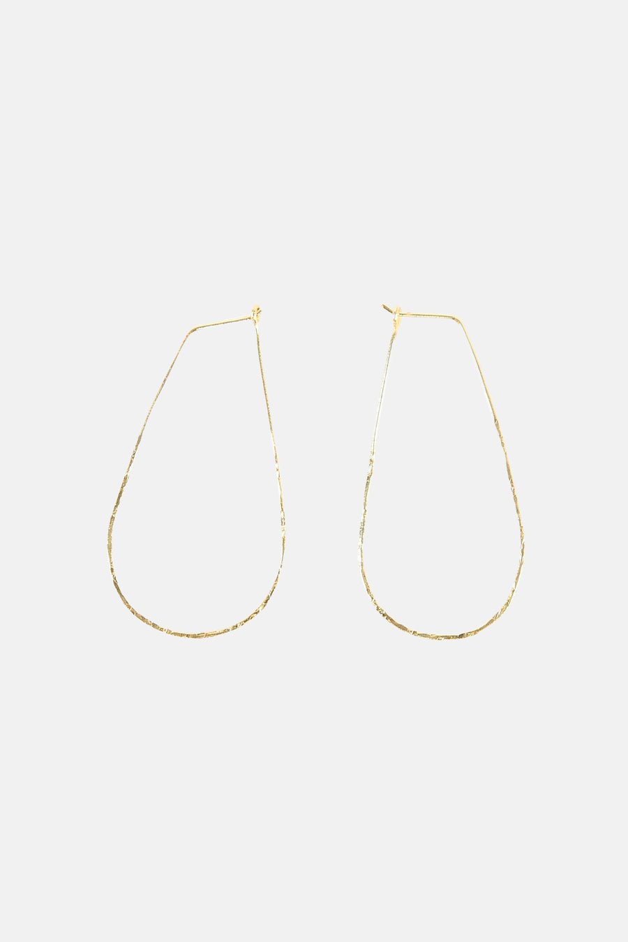 Boucles d'oreilles dorées de Le Fabuleux Marcel de Bruxelles, avec une texture brute et une forme irrégulière unique.