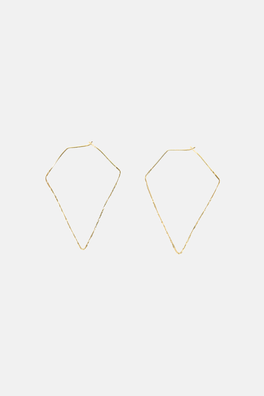 Boucles d'oreilles dorées de Le Fabuleux Marcel de Bruxelles, avec une forme géométrique et une texture irrégulières.