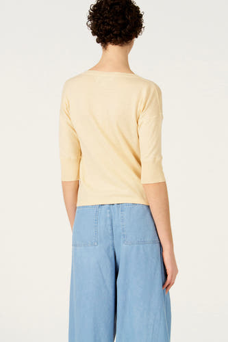 Ecru trui met ronde hals van Le Fabuleux Marcel de Bruxelles, achterkant, gecombineerd met wijde blauwe broek.
