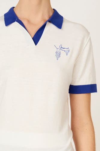 Polo écru à manches courtes de Le Fabuleux Marcel de Bruxelles, avec finition bleue au col et aux manches et broderie.