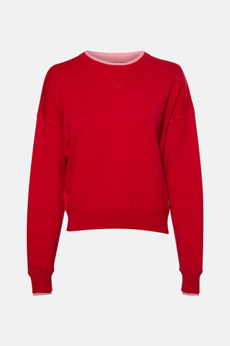 Pull rouge avec col rond de Le Fabuleux Marcel de Bruxelles, avec des accents roses sur la ligne du col et les manchettes.