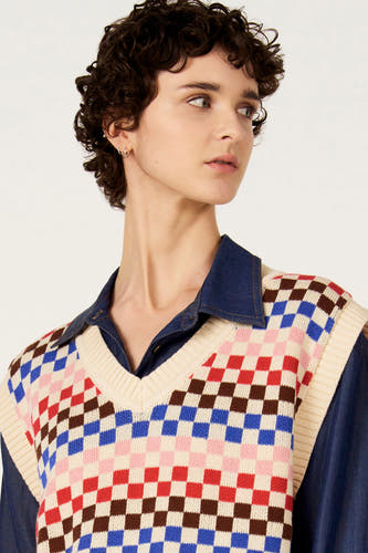 Débardeur multicolore de Le Fabuleux Marcel de Bruxelles, à motif à carreaux et porté sur une chemise en jean bleu.