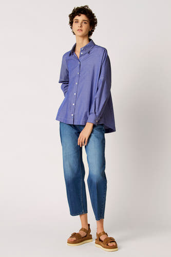 Chemise bleue à rayures à manches longues de Le Fabuleux Marcel de Bruxelles, portée avec un jean et des sandales marron.
