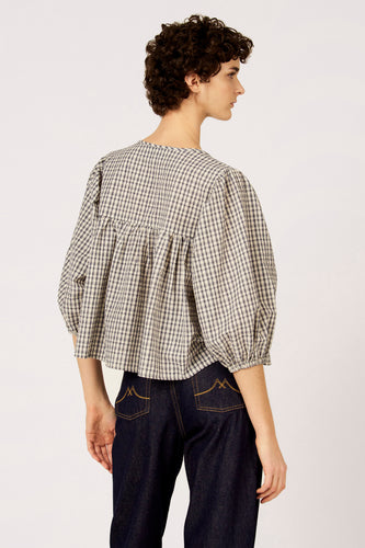 Blauw geruite blouse met driekwart mouwen van Le Fabuleux Marcel de Bruxelles, met geplooide details en donkerblauwe jeans.
