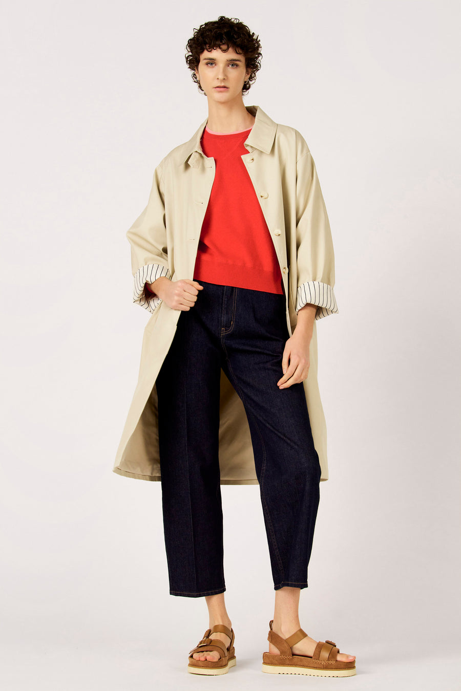Long manteau beige de Le Fabuleux Marcel de Bruxelles, avec des manches trois-quarts et un revers rayé, vu de dos.