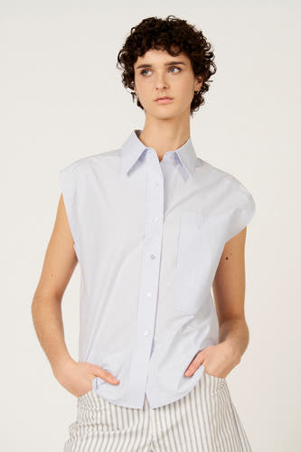 Chemise sans manches bleue de Le Fabuleux Marcel de Bruxelles, avec pantalon à rayures verticales.