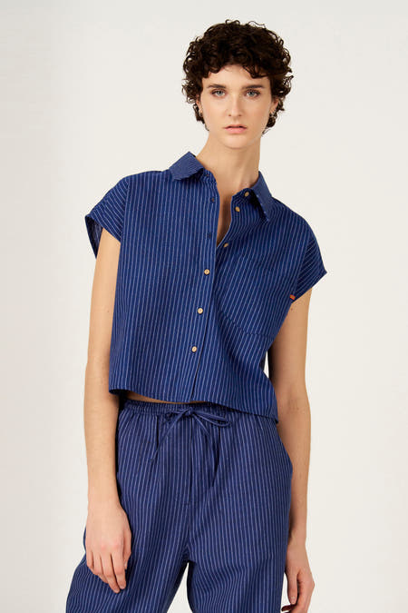 Chemise bleue rayée à manches courtes de Le Fabuleux Marcel de Bruxelles, avec boutons en bois et une poche poitrine.