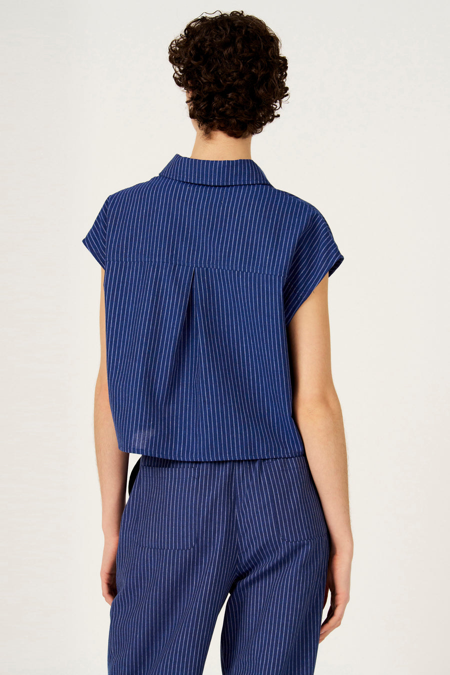 Chemise bleue à rayures à manches courtes de Le Fabuleux Marcel de Bruxelles, vue de dos, faisant partie d'un ensemble assorti.