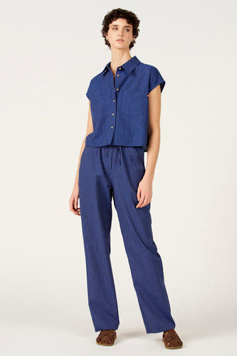 Pantalon en coton bleu de Le Fabuleux Marcel de Bruxelles, avec rayures craie et taille élastique, combiné avec une blouse rayée.