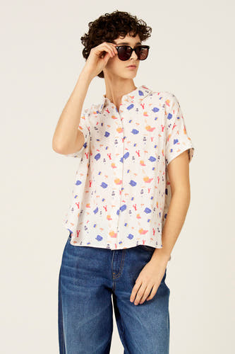 Chemise multicolore à manches courtes de Le Fabuleux Marcel de Bruxelles, à thème plage et portée avec un jean bleu foncé.