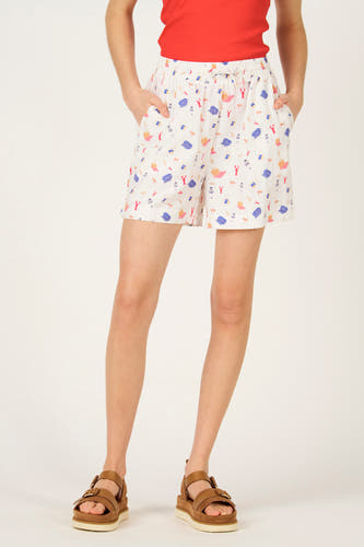 Short multicolore de Le Fabuleux Marcel de Bruxelles, avec motif sur le thème de la plage, combiné avec un haut rouge et des sandales marron.