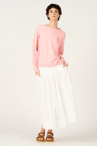 Pull rose de Le Fabuleux Marcel de Bruxelles, avec un col rond et un petit imprimé texte.