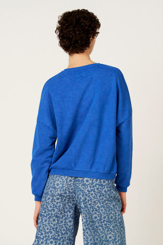 Pull bleu à col rond de Le Fabuleux Marcel de Bruxelles, avec pantalon à manches longues et imprimé fleuri.